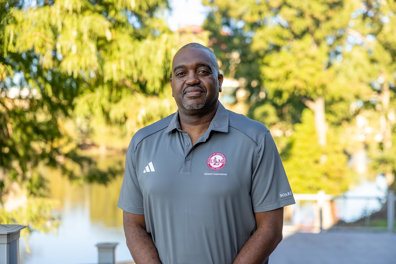 Portrait of Elliott McGlory, ULM Alumni Association Board Member, standing on campus near the bayou.