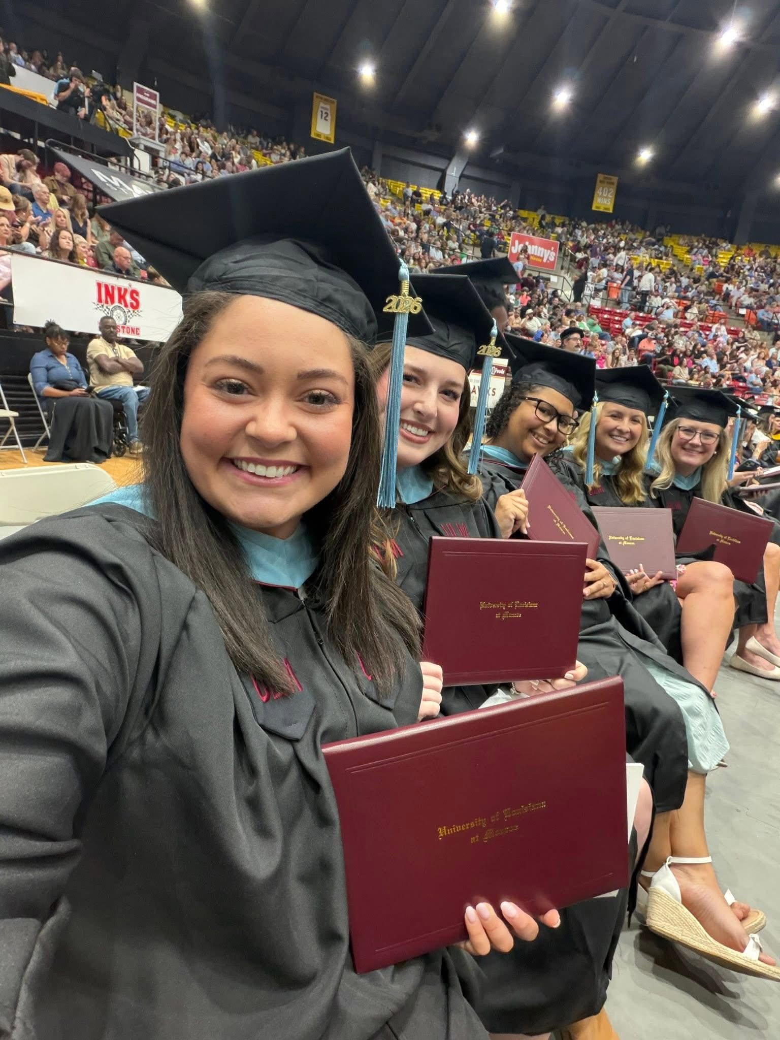 a ULM master's degree graduation ceremony with graduates seated and smiling